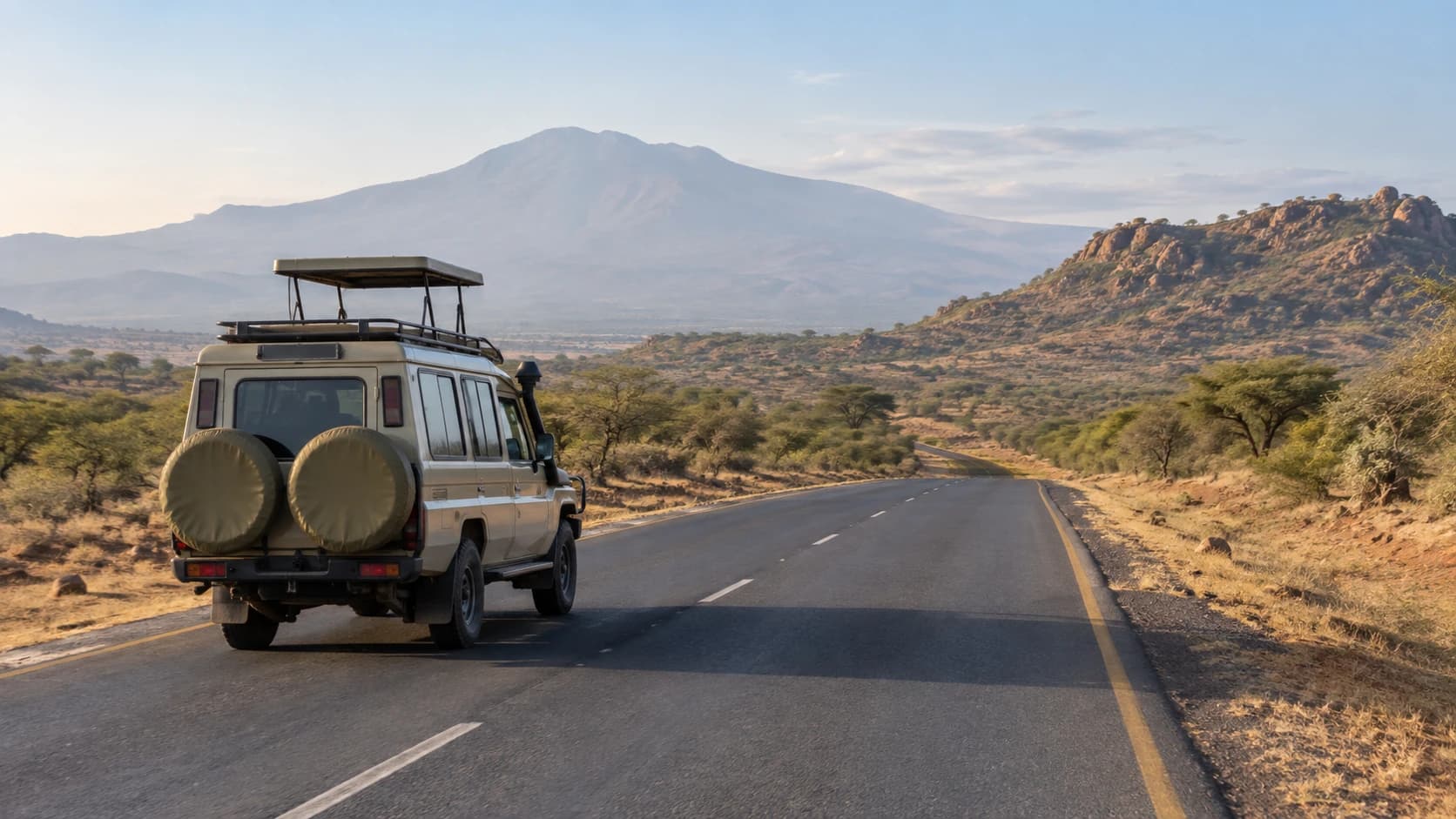 A safari vehicle, the park road and the mountain in the Namanga road corridor